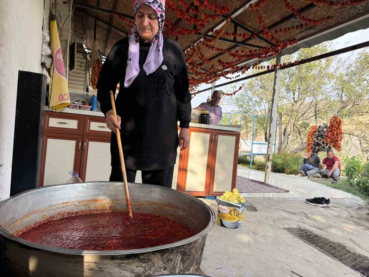 Zeynep Güven, açık alanda büyük bir kazanda reçel hazırlıyor.