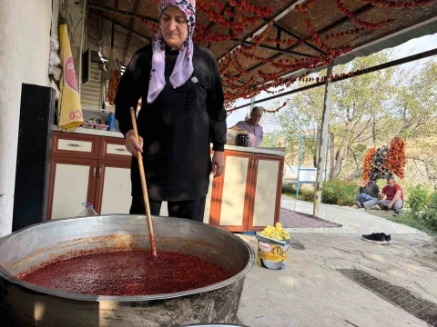 Zeynep Güven, açık alanda büyük bir kazanda reçel hazırlıyor.