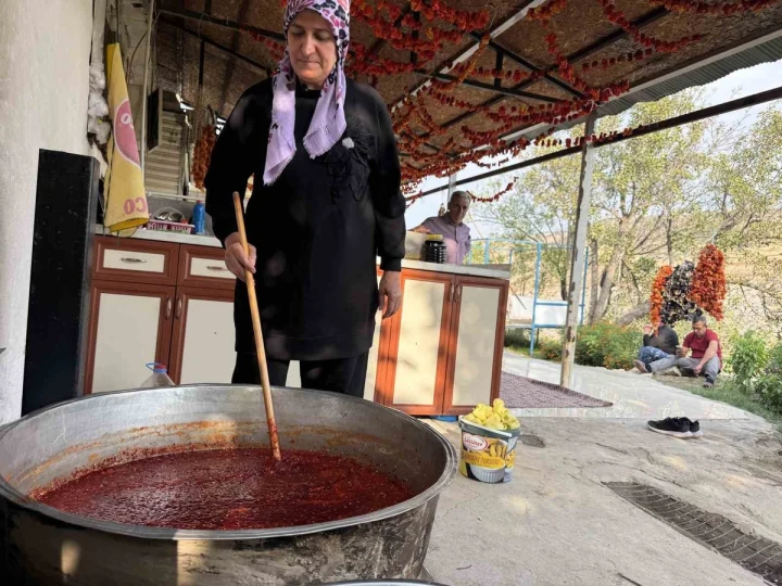Zeynep Güven, açık alanda büyük bir kazanda reçel hazırlıyor.